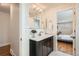 Bathroom with a dark vanity and mirror. The sink has a view of the main bedroom at 6168 Carr St, Arvada, CO 80004