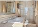 Well-lit bathroom features walk-in shower with glass enclosure and vanity with decorative mirror at 8699 Blue Creek Rd, Evergreen, CO 80439