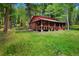 Log cabin home with large yard surrounded by green grass and tall trees at 8699 Blue Creek Rd, Evergreen, CO 80439