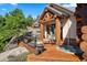 Charming log cabin exterior with wooden deck and relaxing hot tub at 8699 Blue Creek Rd, Evergreen, CO 80439