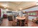 The open-concept living area features wood floors, log walls, and a dining area with seating for four at 8699 Blue Creek Rd, Evergreen, CO 80439