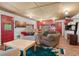 The comfy living area flows into the kitchen featuring red cabinets, white appliances, and log walls at 8699 Blue Creek Rd, Evergreen, CO 80439