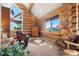 Cozy living room with log walls, large windows offering mountain views, and comfortable seating at 8699 Blue Creek Rd, Evergreen, CO 80439