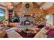 Warm living room with stone fireplace, wood beam ceiling, and cozy furniture, perfect for relaxing and entertaining at 8699 Blue Creek Rd, Evergreen, CO 80439
