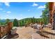 Outdoor deck with a dining area, comfortable seating, and scenic views of the forest at 8699 Blue Creek Rd, Evergreen, CO 80439