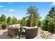 Stone patio with outdoor sectional sofa seating and beautiful views of the surrounding mountains and trees at 8699 Blue Creek Rd, Evergreen, CO 80439