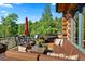 Relaxing outdoor patio seating area with red umbrella overlooking lush trees at 8699 Blue Creek Rd, Evergreen, CO 80439