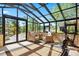 Bright sun room with tile floors, ample seating, and gym equipment with natural light through the skylight windows at 8699 Blue Creek Rd, Evergreen, CO 80439