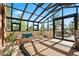 Bright sun room with tile floors, ample seating, exercise equipment, and natural light through the skylight windows at 8699 Blue Creek Rd, Evergreen, CO 80439
