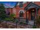 Close-up of a home's brick exterior, front porch, and manicured landscaping at 2815 Curtis St, Denver, CO 80205