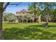 Expansive backyard with lush lawn, mature trees, and a patio area at 81 Falcon Hills Dr, Highlands Ranch, CO 80126