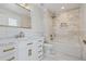 Bright bathroom featuring marble tile, tub and shower, and gold hardware at 81 Falcon Hills Dr, Highlands Ranch, CO 80126