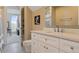 A well-lit bathroom featuring white vanity, toilet, mirror and an open doorway to another living area at 81 Falcon Hills Dr, Highlands Ranch, CO 80126