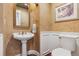 Half-bath with pedestal sink, textured walls, and decorative mirror at 81 Falcon Hills Dr, Highlands Ranch, CO 80126