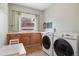 Practical laundry room with a window, washer, dryer, sink, and ample counter space at 81 Falcon Hills Dr, Highlands Ranch, CO 80126