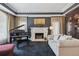 A luxurious living room featuring a grand piano, ornate fireplace, and comfortable seating arrangement at 81 Falcon Hills Dr, Highlands Ranch, CO 80126