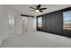 Large bedroom with a decorative accent wall, ceiling fan, and sliding doors that open to reveal the primary bathroom at 10124 Xanadu St, Commerce City, CO 80022