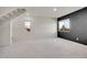 Well-lit open living space featuring a stairway, large windows, neutral carpeting, and stylish contrasting accent wall at 10124 Xanadu St, Commerce City, CO 80022