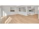 Bright living room featuring wood-look floors, neutral walls, and an open layout to the kitchen at 10124 Xanadu St, Commerce City, CO 80022