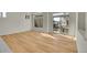 Bright, open floor plan with wood-look floors, neutral walls, and a sliding glass door to the deck at 10124 Xanadu St, Commerce City, CO 80022