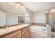 Bathroom featuring double sinks, large mirror, separate tub and shower, offering modern convenience at 2538 Central Park Boulevard, Denver, CO 80238