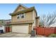 Two story home featuring a detached garage, fenced yard, and a manicured lawn at 2538 Central Park Boulevard, Denver, CO 80238
