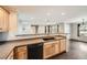Modern kitchen open to the dining area, featuring wooden cabinets, black appliances, and a spacious countertop at 2538 Central Park Boulevard, Denver, CO 80238