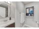 Fresh bathroom with a round mirror, white subway tile, and modern fixtures at 6550 W 74Th Pl, Arvada, CO 80003