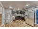 Modern kitchen with stainless steel appliances, gray cabinets, hardwood floors and mosaic backsplash at 6550 W 74Th Pl, Arvada, CO 80003