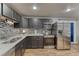 Stylish kitchen featuring stainless steel appliances, dark cabinets, and a mosaic backsplash at 6550 W 74Th Pl, Arvada, CO 80003