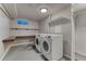 Spacious laundry room with front-loading washer and dryer and built-in shelving at 6550 W 74Th Pl, Arvada, CO 80003
