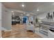 Open concept living room leading to kitchen with stainless steel appliances and hardwood floors at 6550 W 74Th Pl, Arvada, CO 80003