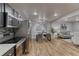 Open floor plan of living and dining areas with stainless steel appliances and sleek, dark cabinetry at 6550 W 74Th Pl, Arvada, CO 80003