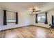 Spacious bedroom with wood-look flooring, ceiling fan, and dual windows with dark curtains at 11042 Blackwolf Ln, Parker, CO 80138