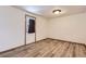 An empty bedroom with wood floors, a white door with a brown curtain and natural light at 11042 Blackwolf Ln, Parker, CO 80138
