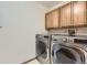 Laundry room featuring new stainless steel washer and dryer with warm wooden cabinets at 11042 Blackwolf Ln, Parker, CO 80138