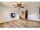 Living room with wood-look floors, a ceiling fan, and convenient access to other areas of the home at 11042 Blackwolf Ln, Parker, CO 80138