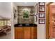 Charming home bar with a stone backsplash, custom cabinets, and glass shelves at 10227 Osceola Ct, Westminster, CO 80031