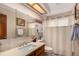 Bright bathroom featuring a single sink vanity, framed mirror, and a combined bathtub and shower with a shower curtain at 10227 Osceola Ct, Westminster, CO 80031