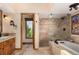 Modern bathroom with natural stone finishes, a walk-in shower, and dual sink vanity at 10227 Osceola Ct, Westminster, CO 80031