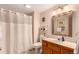 Neutral bathroom with a single sink vanity, a framed mirror, and a bathtub and shower with a shower curtain at 10227 Osceola Ct, Westminster, CO 80031