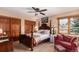 This bedroom features a four-poster bed with a wooden frame, a window, a ceiling fan, and a red sofa at 10227 Osceola Ct, Westminster, CO 80031
