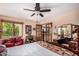 This bedroom features a full bed, window, ceiling fan, red loveseat, a bookshelf and a door at 10227 Osceola Ct, Westminster, CO 80031