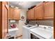 Functional laundry room with wooden cabinets, washer and dryer, and utility sink at 10227 Osceola Ct, Westminster, CO 80031