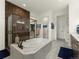 A luxurious bathroom featuring a modern shower with a glass door, plus a soaking tub with marble accents at 5492 Woodroot Pt, Castle Rock, CO 80104