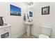 Elegant powder room with a pedestal sink, modern fixtures, and stylish decor at 5492 Woodroot Pt, Castle Rock, CO 80104