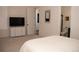 Bright bedroom featuring neutral tones, a TV, and a glimpse into an ensuite bathroom at 5492 Woodroot Pt, Castle Rock, CO 80104