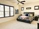 Bright bedroom with a large window, ceiling fan, and neutral carpet at 5492 Woodroot Pt, Castle Rock, CO 80104