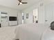 A well-lit bedroom with a ceiling fan, a TV on a dresser, and a view of other rooms through open doorways at 5492 Woodroot Pt, Castle Rock, CO 80104