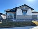 Well-kept home featuring stone accents, gray and white siding, and a manicured front yard at 5492 Woodroot Pt, Castle Rock, CO 80104